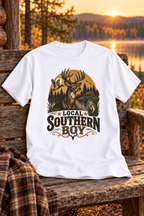 Local Southern Boy graphic T-shirt in white on a rustic cabin bench beside a lake